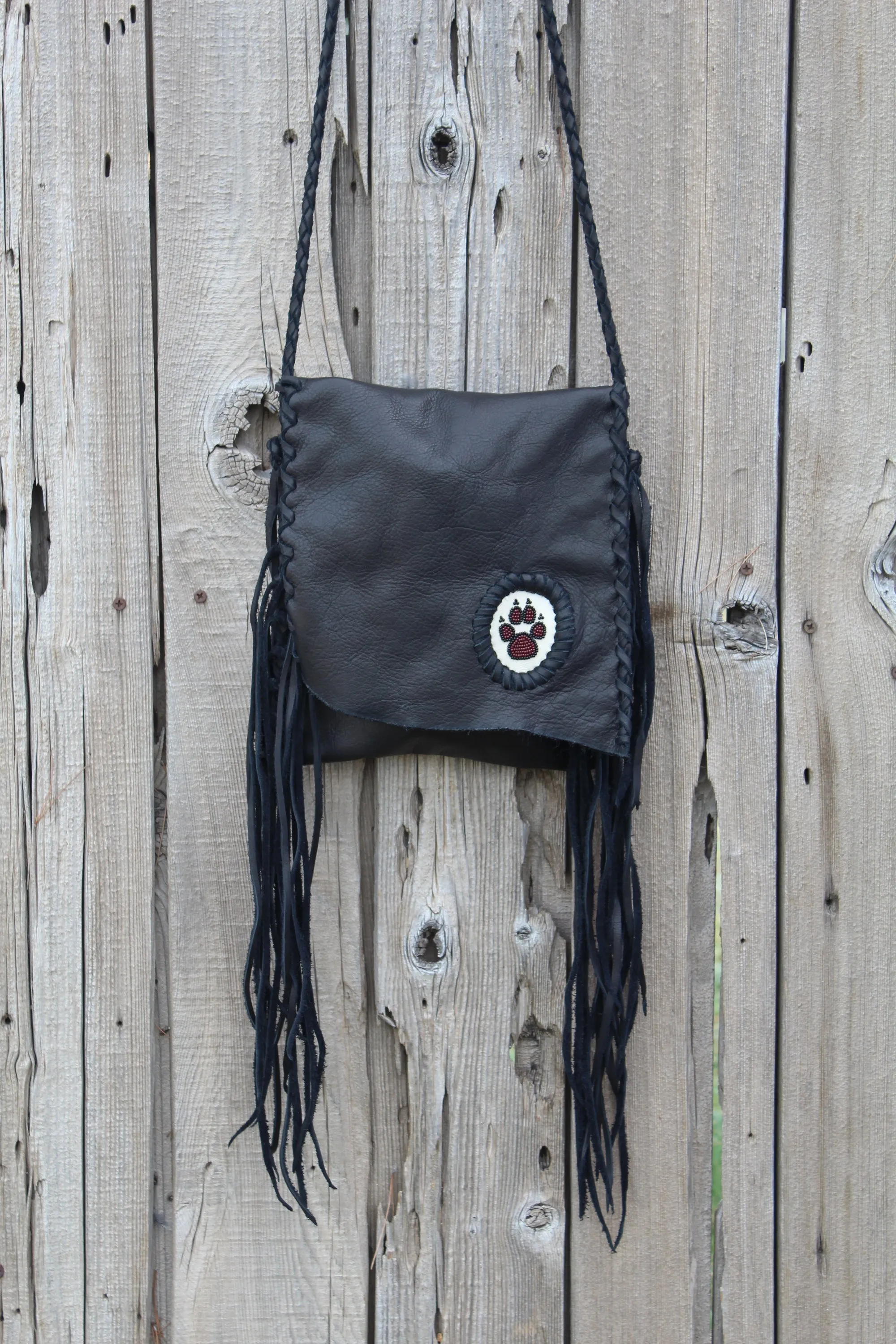 Black leather fringed handbag, beaded wolf paw design